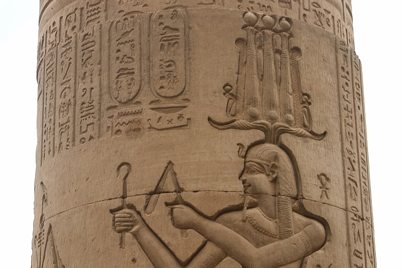 37 MAK_6352pp.jpg - ...indossa una corona Hemhem molto complessa composta da tre corone atef (canne di papiro sormontate da un disco solare e piume) poste su corna di ariete intrecciate e cobra, simboleggiava il potere regale, la protezione divina e il trionfo sui nemici. Tiene in mano lo scettro Heka (il bastone ricurvo) e il flagello Nekhakha, simboli tradizionali del potere e della sovranità nell'antico Egitto.